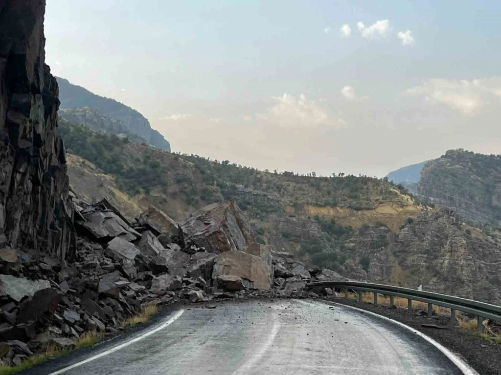 GIANT ROCKS DISLODGED FROM THE HILLSIDE FOLLOWING RAINFALL BLOCK THE HIGHWAY